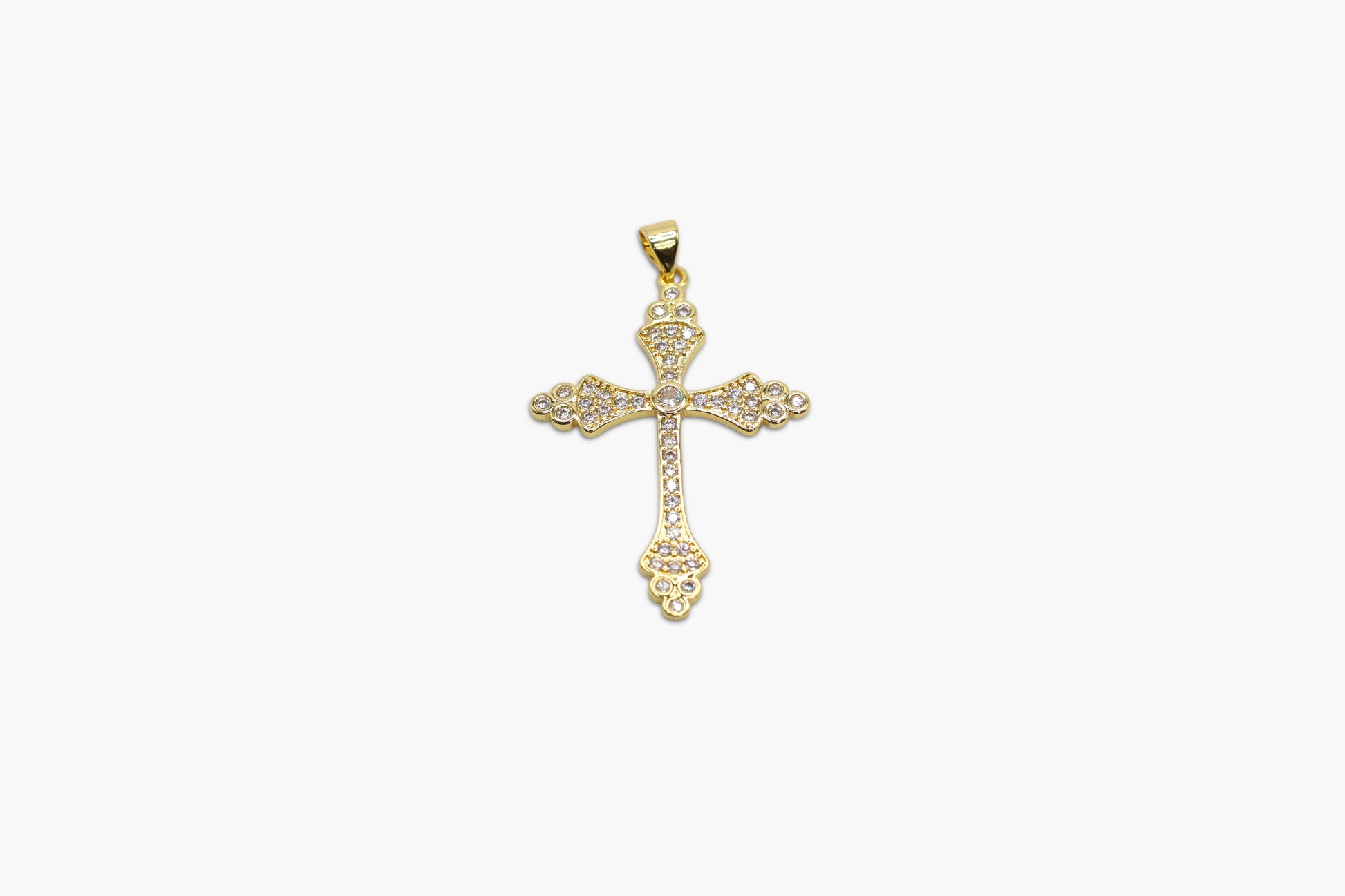 Gold cross pendant on a white background