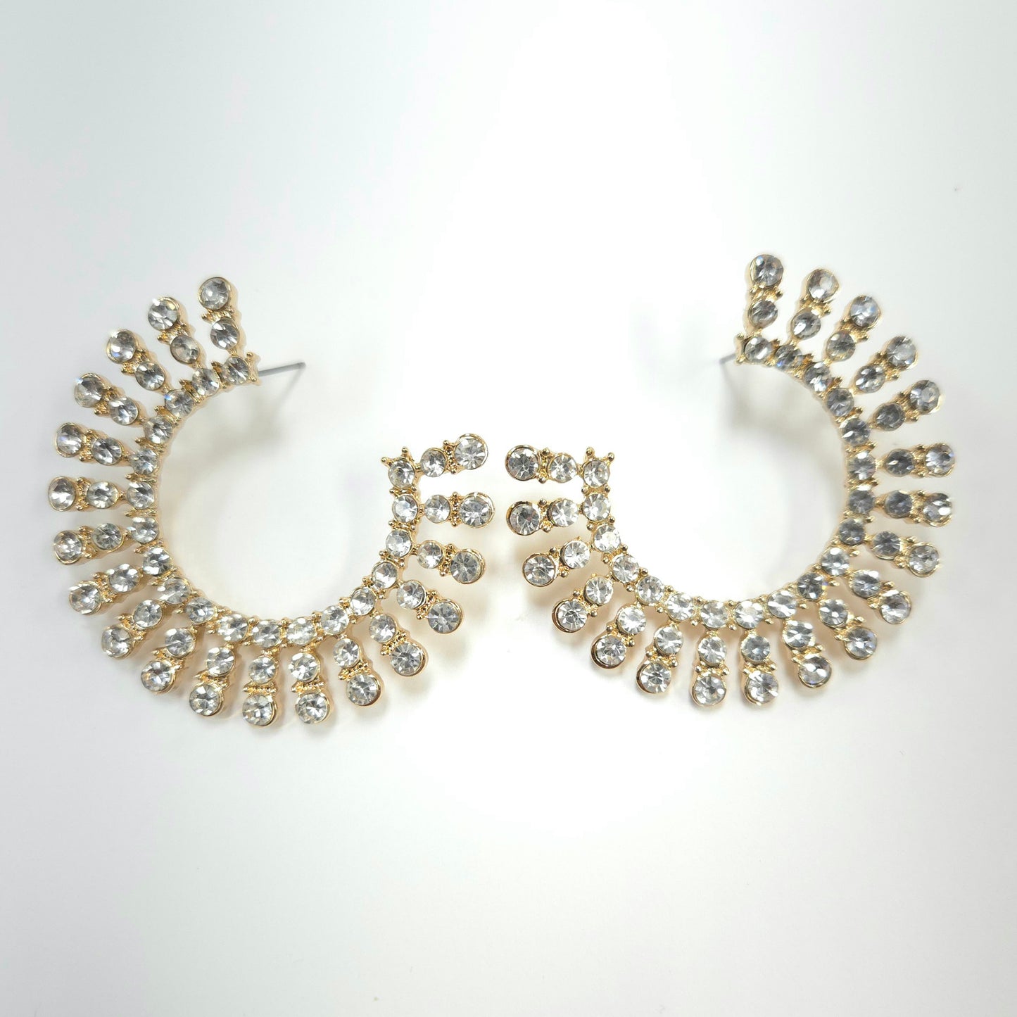 Pair of gold hoop earrings with crystal embellishments on a white background