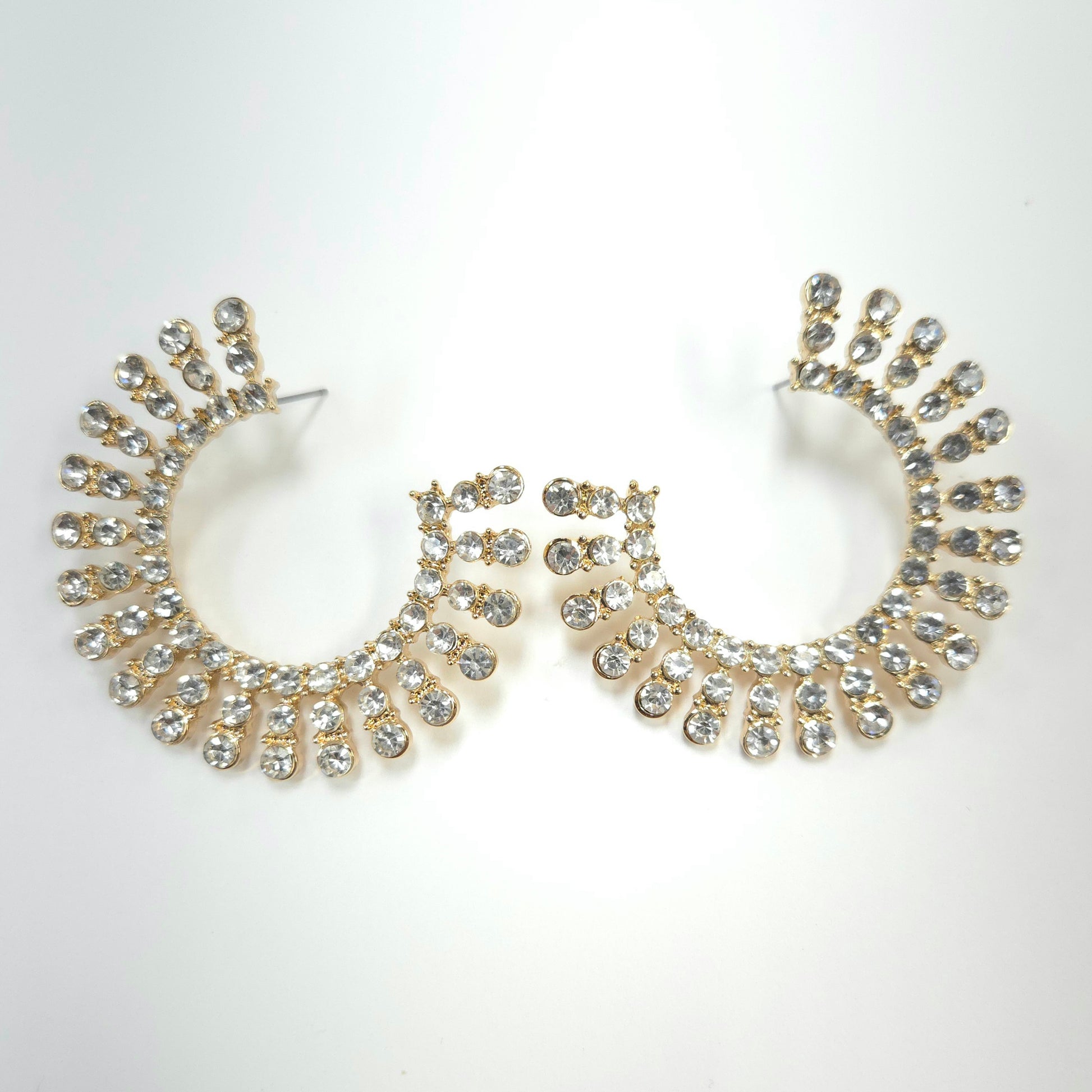 Pair of gold hoop earrings with crystal embellishments on a white background