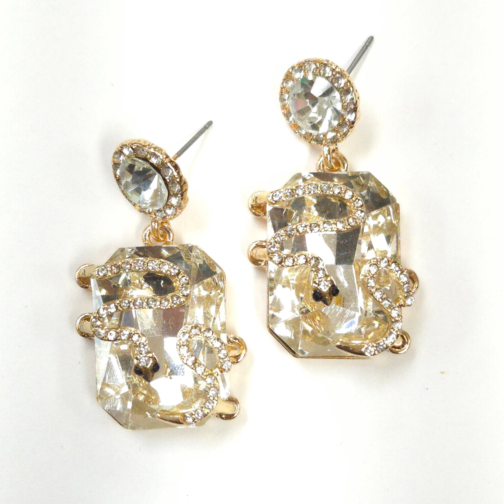 Pair of gold and crystal earrings on a white background