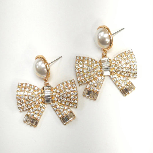 Bow-shaped earrings with pearl centers on a white background
