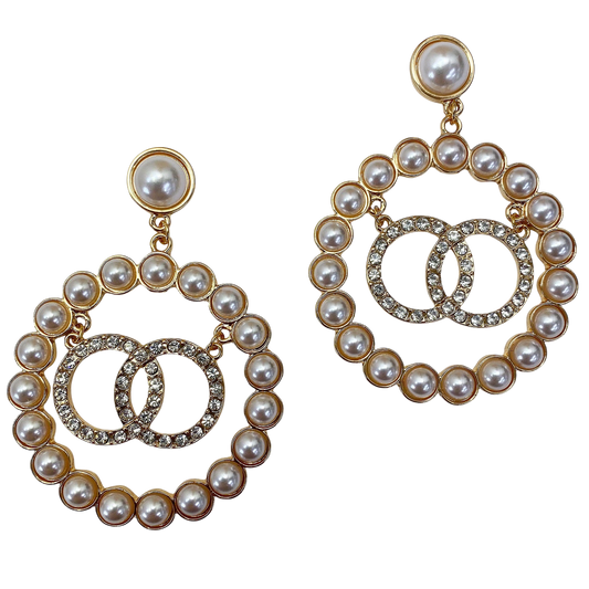 Pair of pearl and gold hoop earrings on a white background