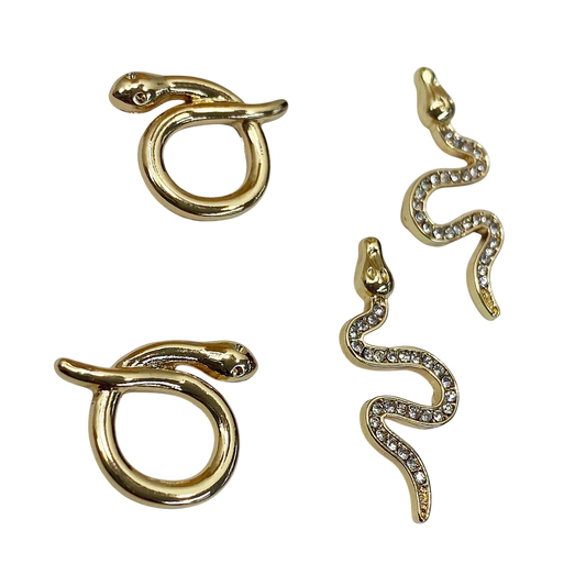 Gold snake-shaped earrings on a white background